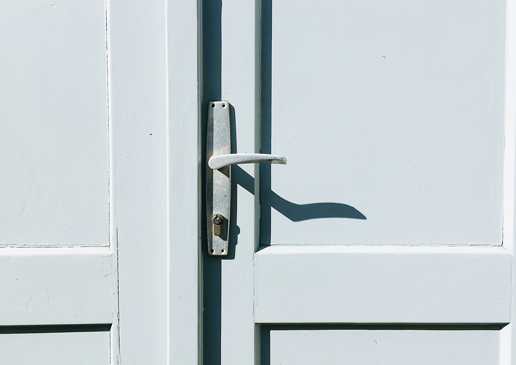 Door handle on old door with harsh shadows