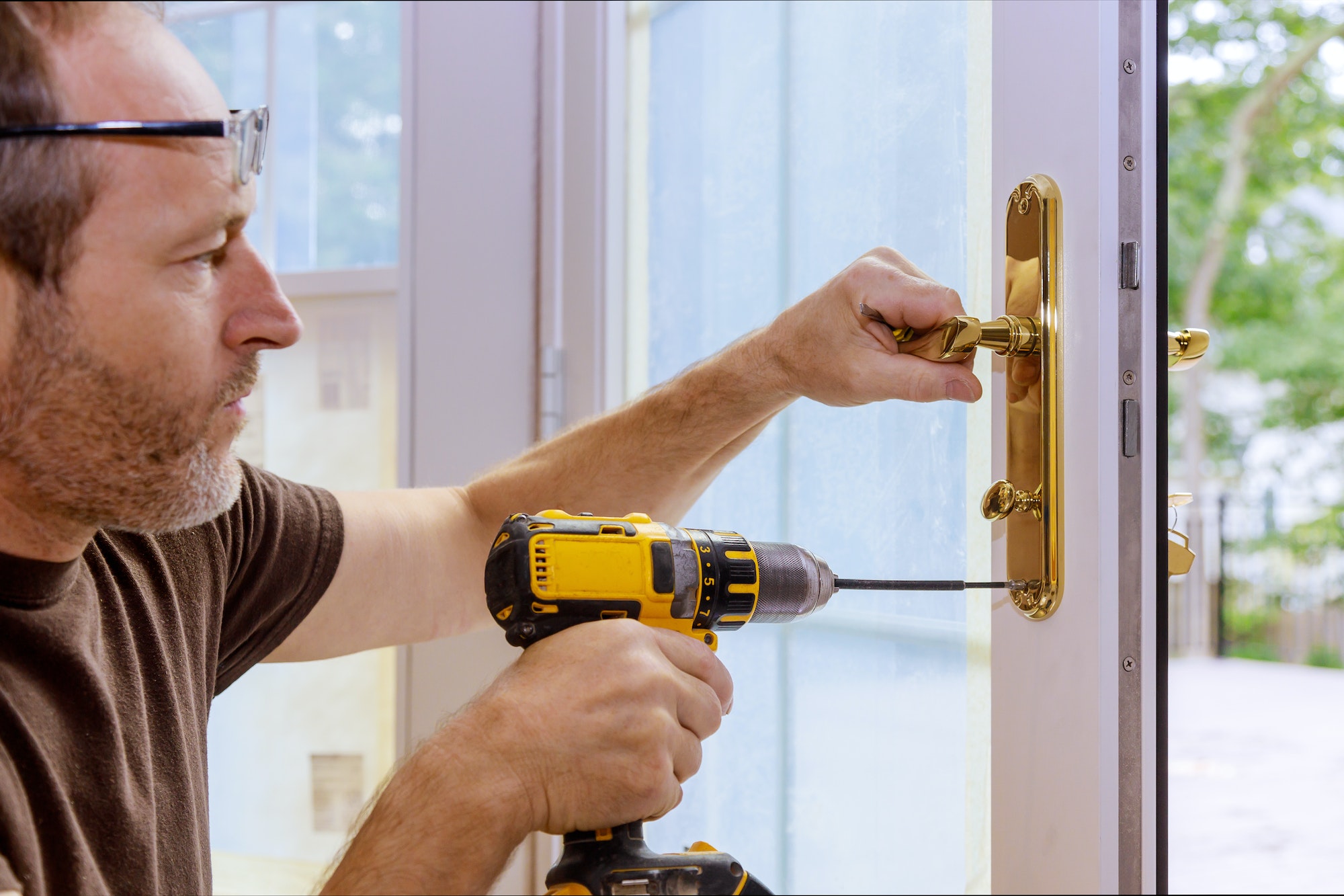 Closeup of a professional locksmith installing or repairing a new deadbolt lock